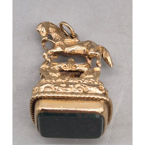 74 - 9ct yellow gold ornate horse figural fob seal. Blood stone. 15.47grams.