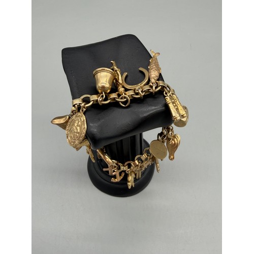 76 - 9ct yellow gold charm bracelet and charms. 22.09grams.