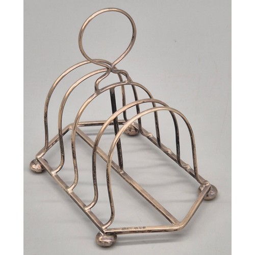 49 - A Selection of silver wares; Chester silver four slice toast rack- produced by Nathan & Hayes. Birmi... 