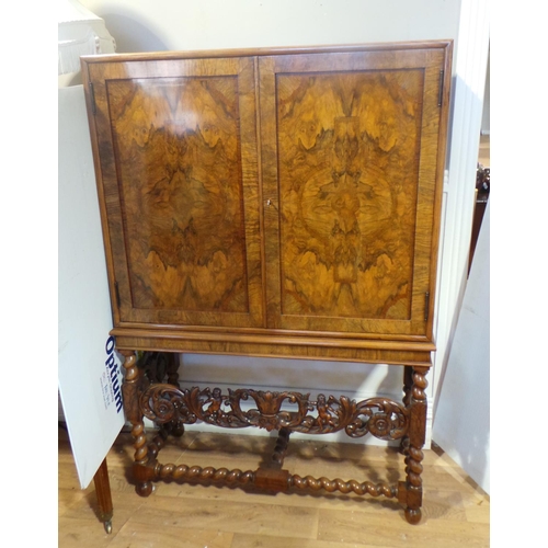 73 - Figured walnut cabinet, twin panel doors revealing a shelved interior