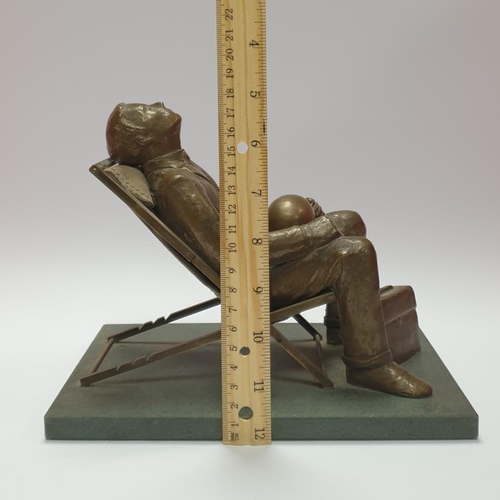 9 - Cast Crass Model of a man reclining on a deck chair, 18cm high