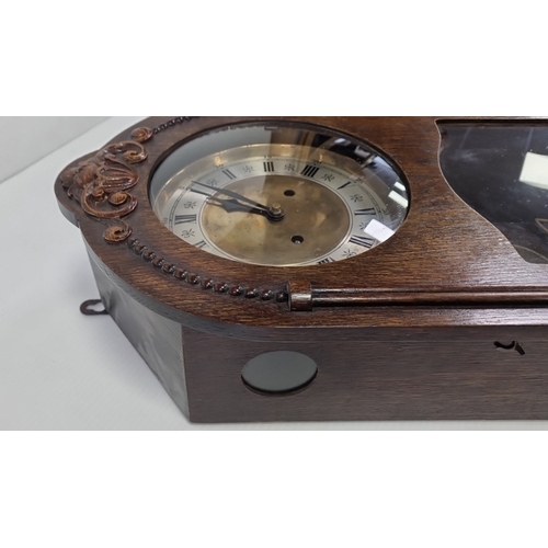 227 - Carved wooden wall clock with pendulum and key, H: 61cm x W: 31cm x D: 15cm