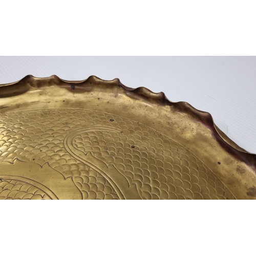 11 - Large Brass charger with chased rosette and scroll decoration, Diameter: 54cm.