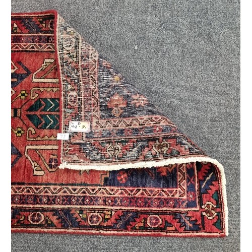 34 - Large and woven Persian  Heriz runner medallion design , L:404cm X W: 90cm.