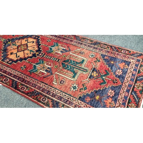 34 - Large and woven Persian  Heriz runner medallion design , L:404cm X W: 90cm.