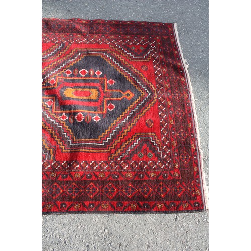 1904 - Red ground rug with central 