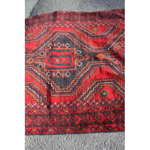 1904 - Red ground rug with central 