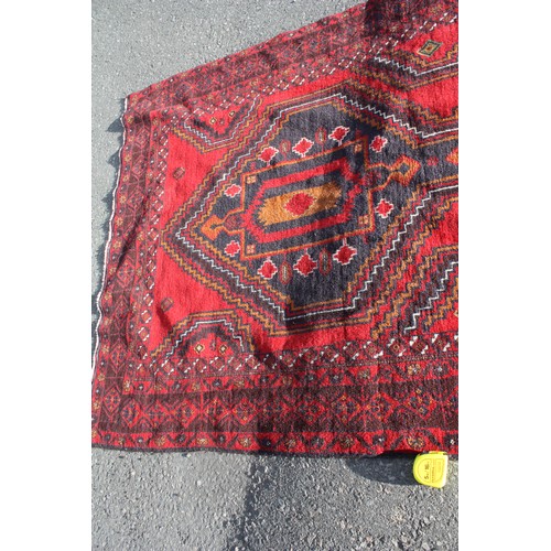 1904 - Red ground rug with central 