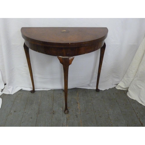 10 - A demi-lune mahogany card table with walnut veneered top on four cabriole legs, A/F