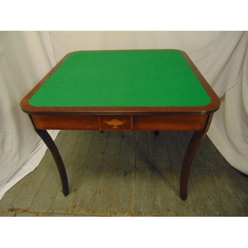 14 - A rectangular mahogany games table with hinged top revealing a green baize on four sabre legs