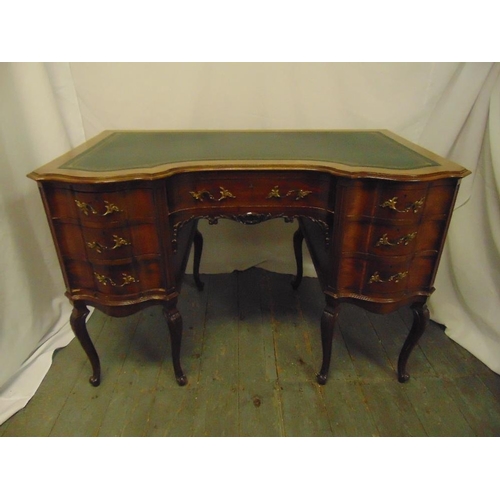 2 - An Edwardian shaped rectangular mahogany kneehole desk with tooled leather top, brass handles, on ca... 