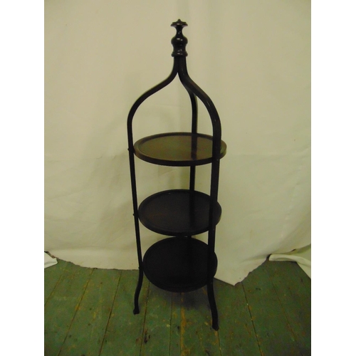 23 - A three tier mahogany tea stand surmounted by baluster finial on three scrolling legs