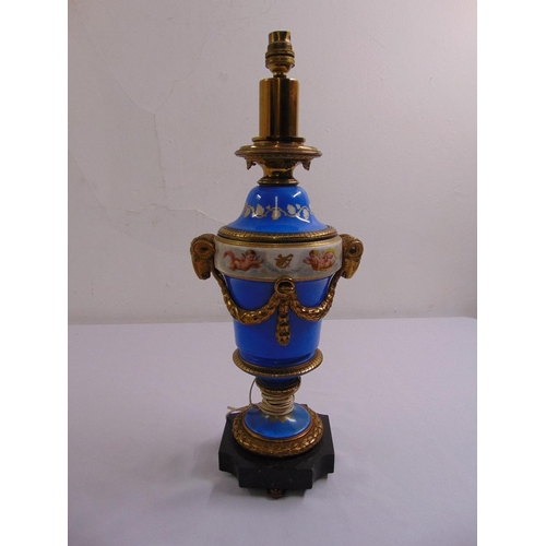 47 - A French Sevres style lamp base with gilt rams heads, decorated with putti and gilded metal mounts