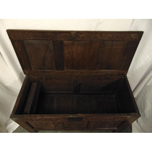 34 - An early rectangular oak coffer with carved side panels, hinged cover and bracket feet