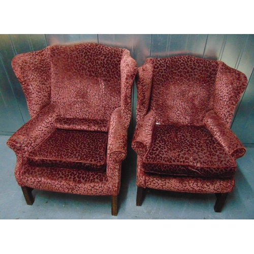 12 - Two upholstered wing back armchairs on four tapering rectangular legs