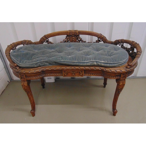 15 - A late 19th century French bedroom seat, shaped oval carved with swags with bergere seat, on four sc... 