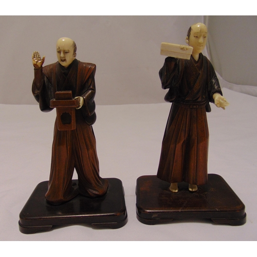 164 - Two oriental carved wooden figurines on rounded rectangular bases, 20cm (h)