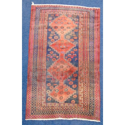 19 - A Persian wool carpet geometric medallions against a red and blue ground within blue borders, 216 x ... 