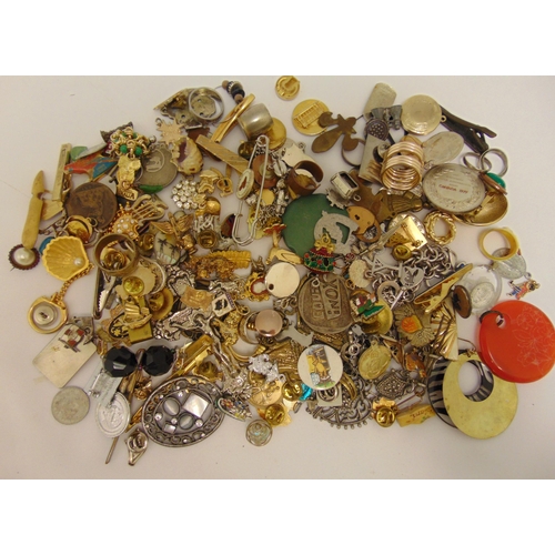 272 - A quantity of costume jewellery to include badges, tie clips, rings and charms