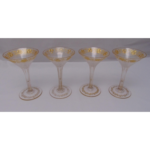 169 - A set of four continental fluted ice cream glasses decorated with gilded flowers and leaves on raise... 