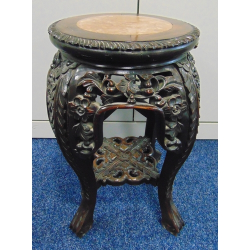 17 - An oriental hardwood garden seat carved with leaves and flowers and marble inset to the top on four ... 