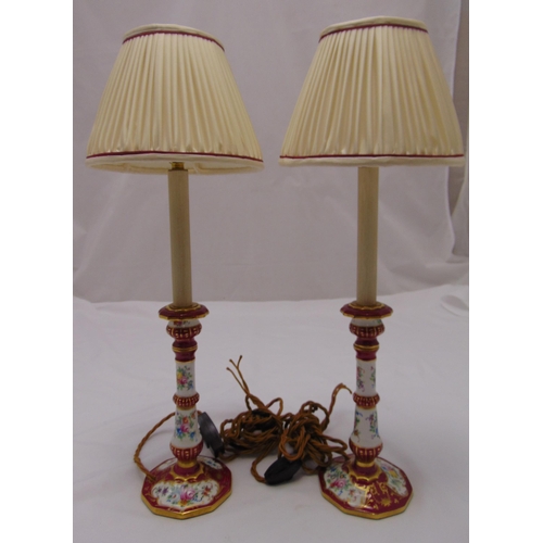 43 - A pair of porcelain table lamps, knopped cylindrical form on raised circular bases with silk shades,... 