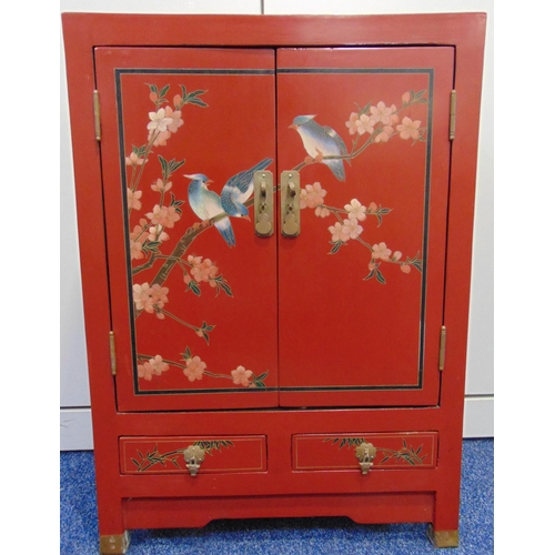 18 - An oriental rectangular red lacquered cabinet, the hinged doors with birds and prunus blossom above ... 