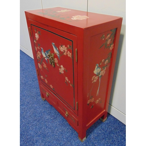 18 - An oriental rectangular red lacquered cabinet, the hinged doors with birds and prunus blossom above ... 