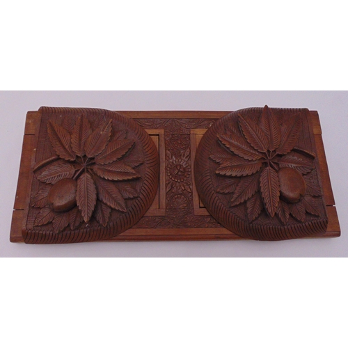 209 - A rectangular carved wooden book slide, the hinged ends carved with stylised leaves, 33cm (w)