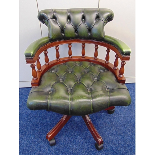 22 - A reproduction Captains chair of customary form, the scroll legs on original castors