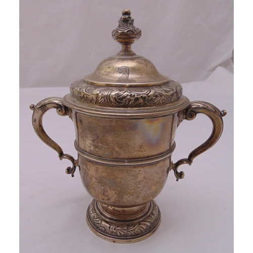 394 - George II hallmarked silver twin handled trophy cup and cover with engraved crest to the side, Londo... 