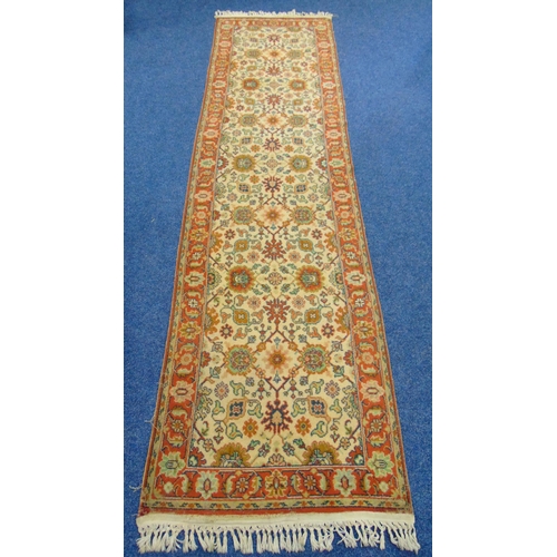 40 - A wool runner, cream ground with repeating pattern and red border, 3.5m x 90cm