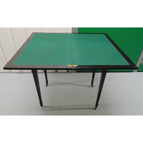 9 - An Edwardian rectangular ebonised games table, the hinged cover revealing a baize interior all on fo... 