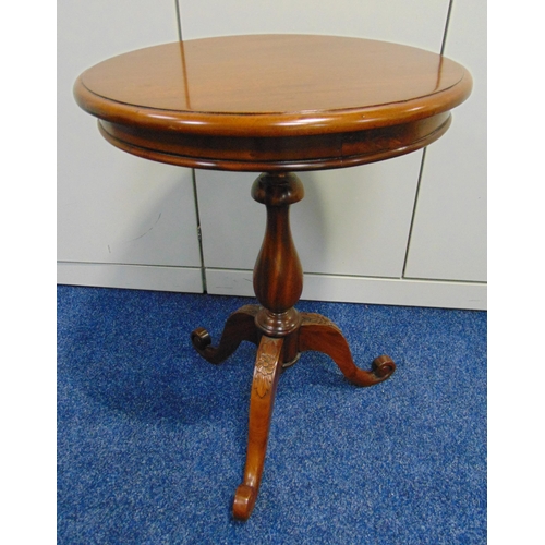 11 - A circular mahogany side table on three outswept legs, 65 x 49cm