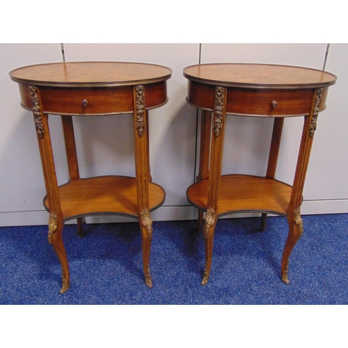 8 - A pair of continental mahogany and Kingswood oval side tables with single drawer on four scroll supp... 