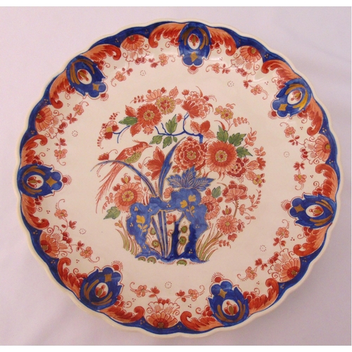 111 - An early 20th century Delft charger decorated with flowers and leaves, 31cm (d)