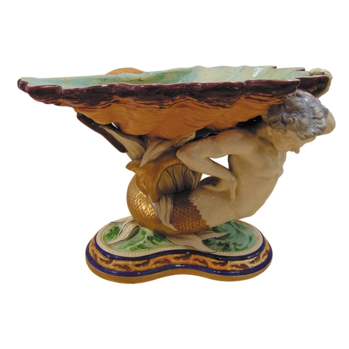 98 - A 19th century Majolica centre piece in the form of a merman supporting a shell shaped dish on raise... 