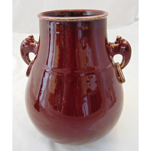 156 - A Chinese ox blood red glazed baluster vase with side handles, marks to the base, 26cm (h)