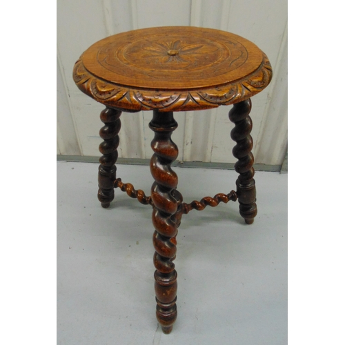 21 - An oak circular milking stool on three barley twist legs and stretchers, 46 x 30cm