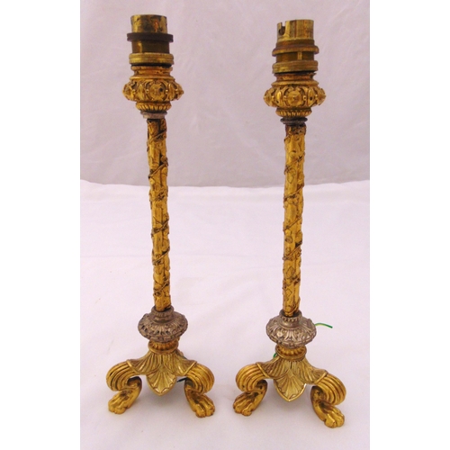 27 - A pair of gilt metal table candlesticks, the ivy bound columns on triform claw feet, converted to el... 