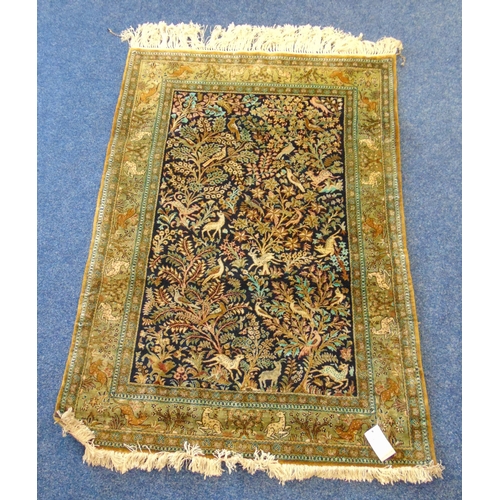 30 - A Persian silk Qum carpet decorated with birds and deer within a blue background and a repeating bor... 