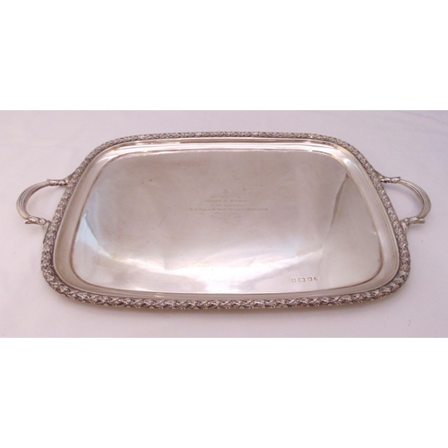 361 - A hallmarked silver presentation tea tray, rounded rectangular with husk border and two leaf mounted... 