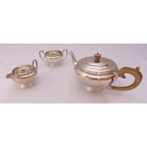 368 - A hallmarked silver three piece tea set, compressed cylindrical with scroll handles on raised circul... 