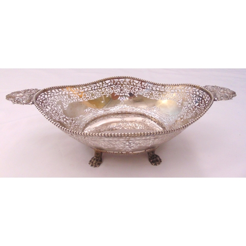 372 - A continental white metal oval bread basket, scroll pierced sides engraved with peacocks on four cla... 