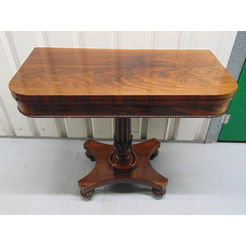 8 - A Regency mahogany games table on fluted columnular support with quatrefoil stand on carved bun feet... 