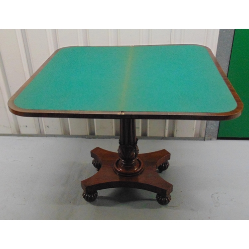 8 - A Regency mahogany games table on fluted columnular support with quatrefoil stand on carved bun feet... 