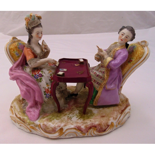 138 - A continental porcelain figural group of a lady and gentleman playing cards on shaped naturalistic b... 