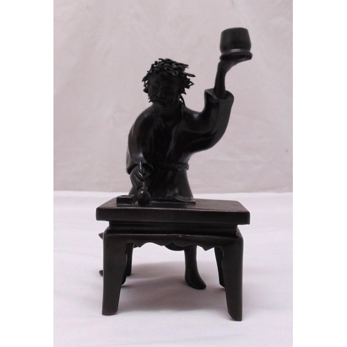 184 - An oriental bronze figurine of a scholar at his desk, 23.5cm (h)