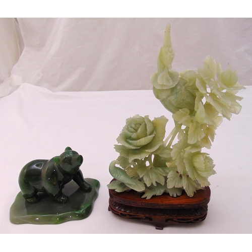 193 - A jade figurine of a bear on carved stand and a carved hardstone figurine of birds and flowers on ha... 