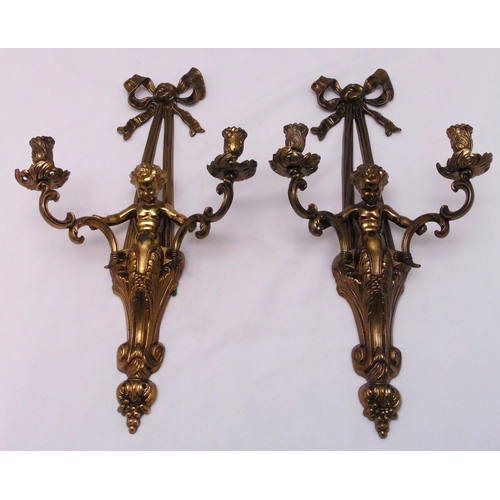 205 - A pair of gilt metal  two light wall sconces in the form of putti supporting scroll branches, 56cm (... 